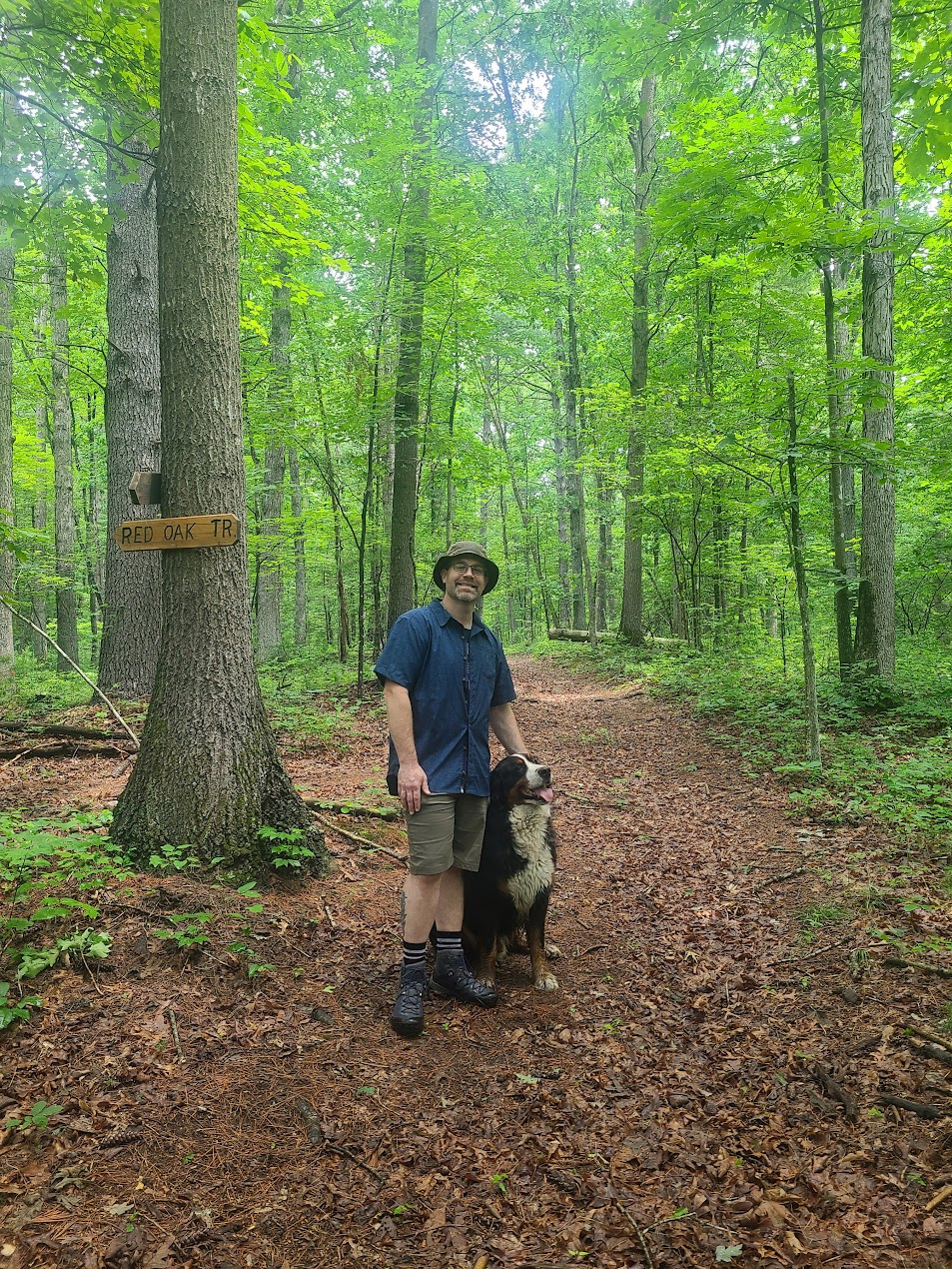 Josh Kaplan hiking on Red Oak Trail with a friendly dog he met along the way